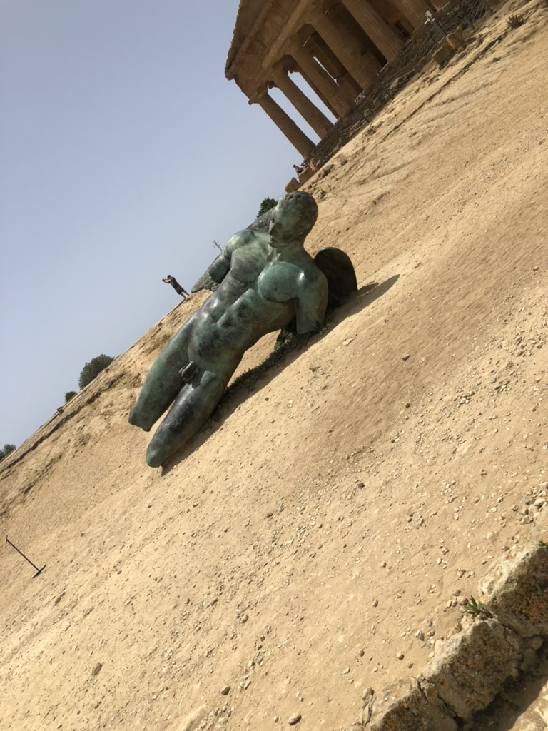 Bronze statue of Icarus lying in front of the Temple of Concordia at Valle dei Templi in Agrigento, Sicily.